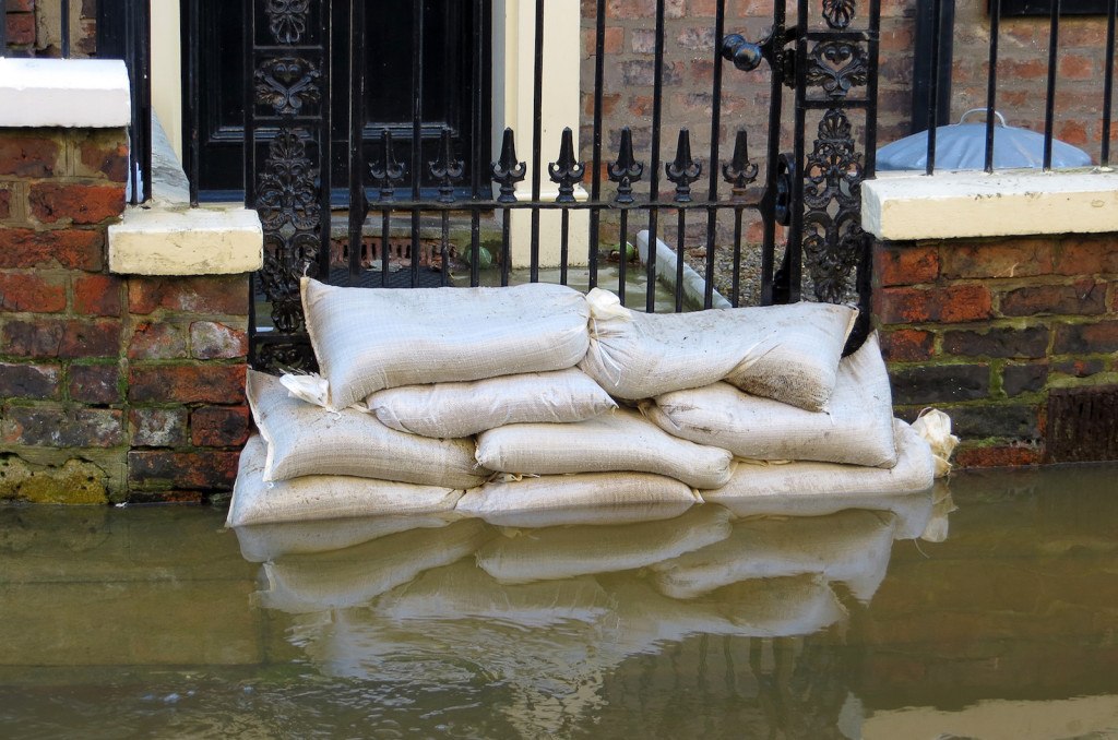 Sandbags stacked in front of house in York flooded street.