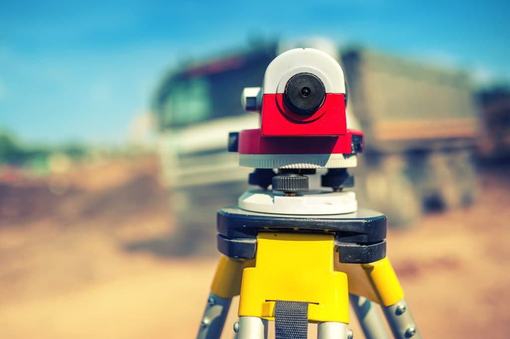 Surveying measuring equipment level theodolite on tripod at construction site