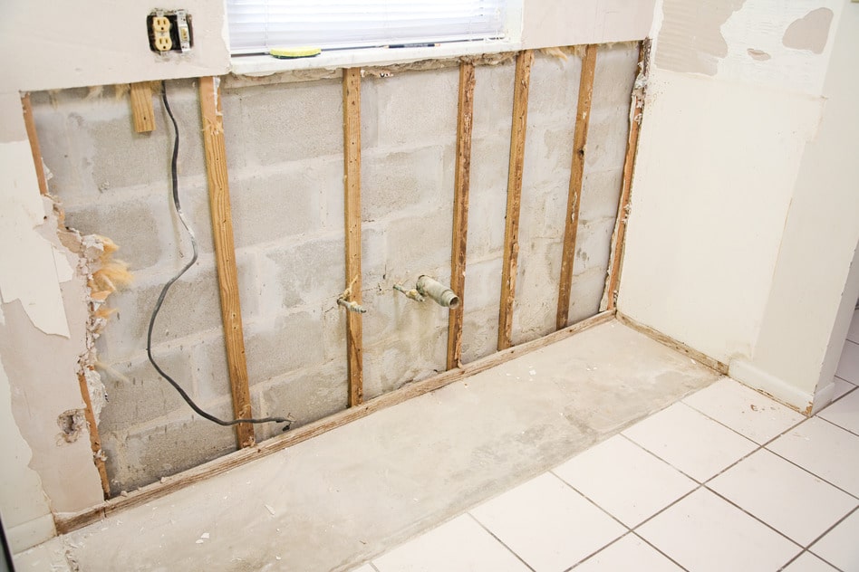 Interior of kitchen with drywall torn out because of water damage and the resulting mold.